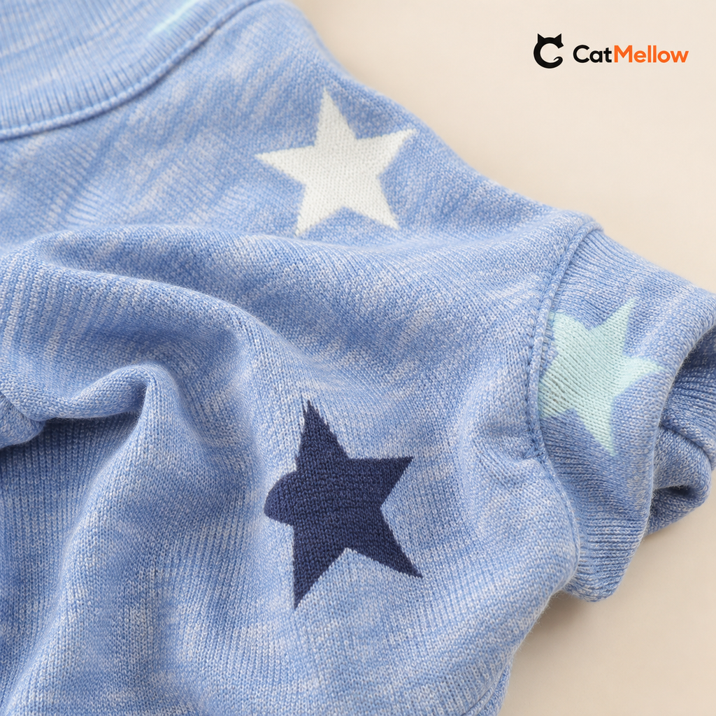 Close-up of pale heather-blue fabric with white, pale pink, mint, and navy stars