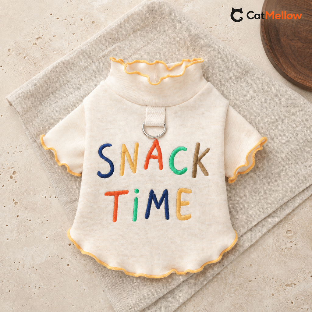 Cream CatMellow Snack Time embroidered cat T-shirt laid flat on neutral linen and stone