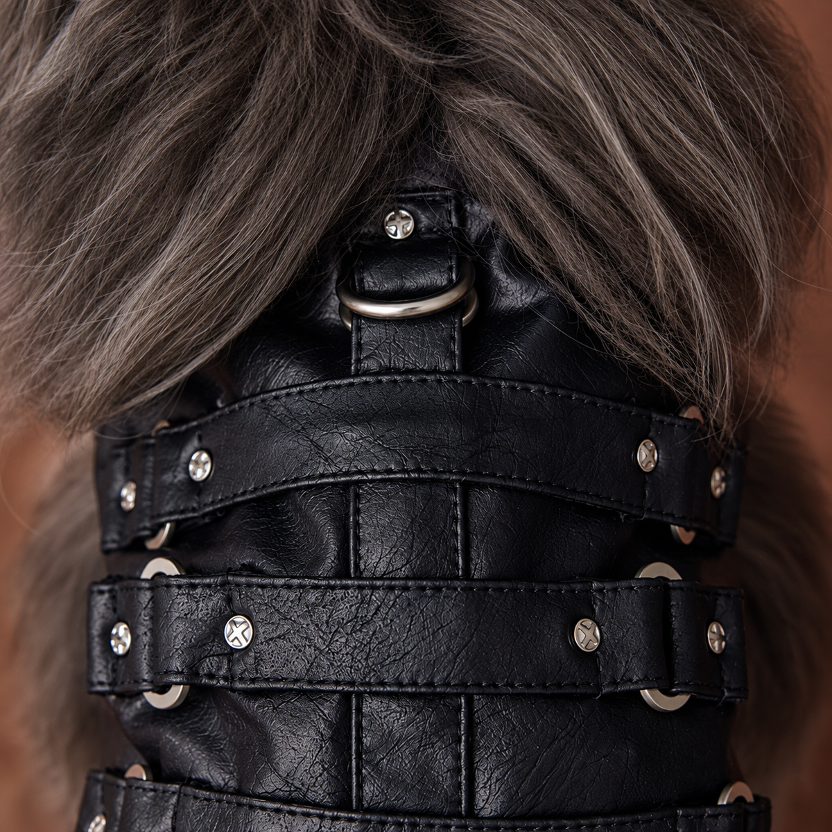 Close-up of black vest straps, silver-tone hardware and textured finish