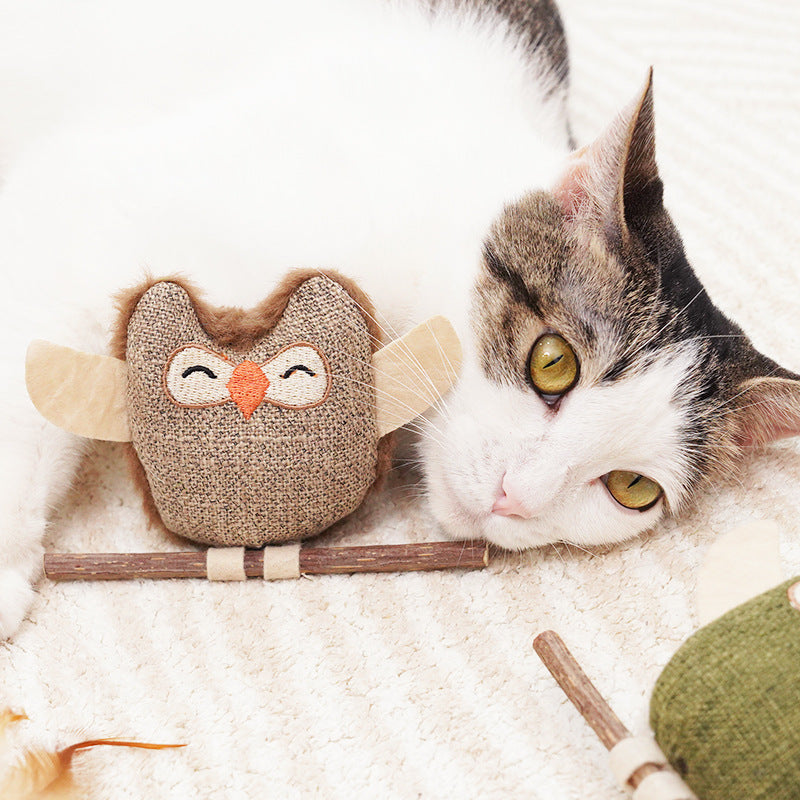 Cat resting beside the brown owl toy